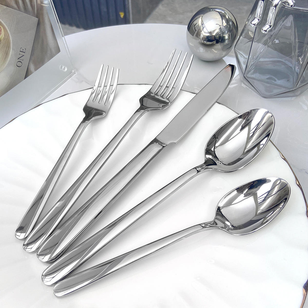 Luxury stainless steel cutlery set with leather handles, including spoon, fork, knife

